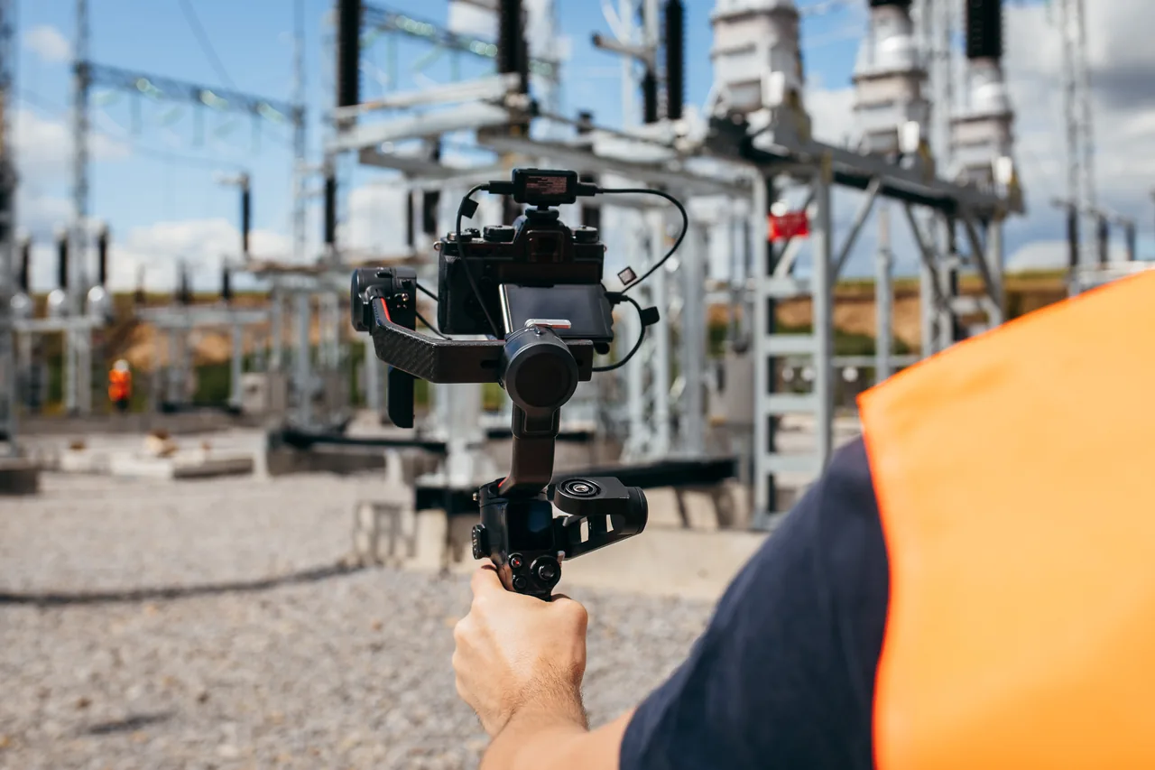 Cámara con estabilizador grabando en una instalación eléctrica durante una jornada de seguimiento de obra